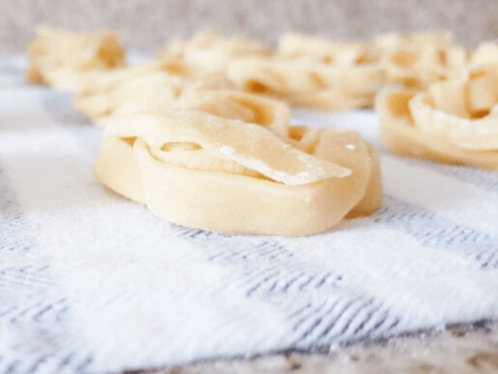 Homemade noodles in a nest drying on a kitchen towel.